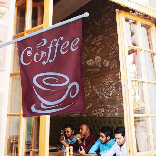 Custom Flags 22 Outdoor custom storefront flag with a coffee logo hanging outside a café