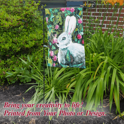 Custom garden flag with bunny design placed in lush greenery.